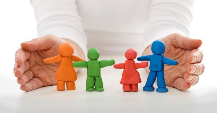 Clay people family protected by woman hands - life insurance concept